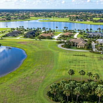 Aerial view of Burnt Store Lakes, Florida, showing vacant residential lots, canal waterways, and palm-lined streets—used as a banner for UNITY’s land selling services.